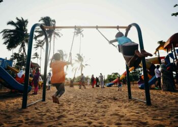Bambini che corrono e giocano in un prato al tramonto, godendosi la natura in un ambiente sicuro